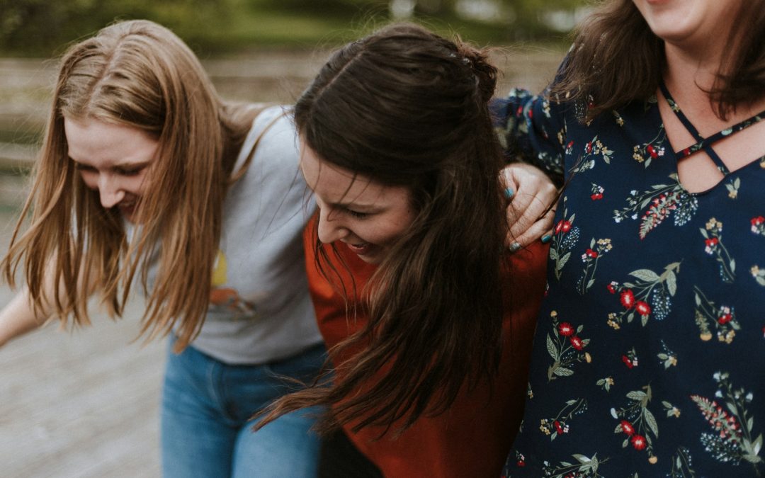 three woman holding each other and smiling while taking a photo